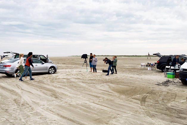 Das Team der Bild- und Videoproduktion bei Aufnahmen am Strand - Windrich & Sörgel